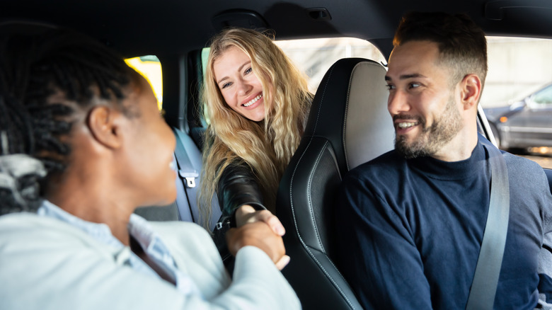 people greeting each other in car