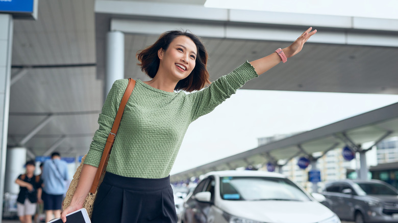 Woman hailing airport taxi