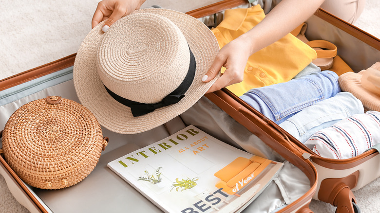 Lady packing items in a suitcase