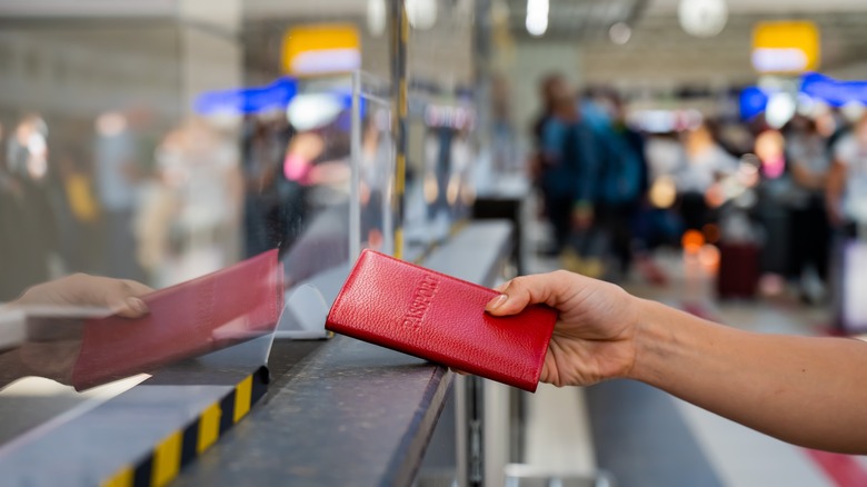 person handing passport at immigration