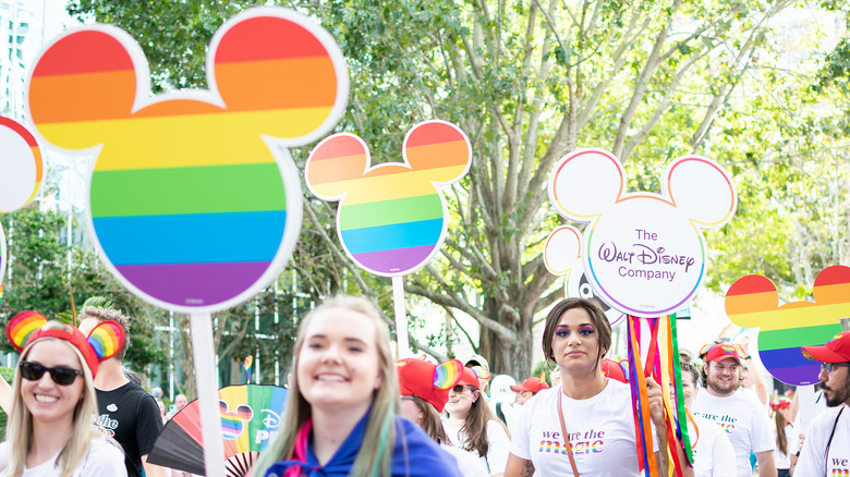 Cast members carrying rainbow Mickeys