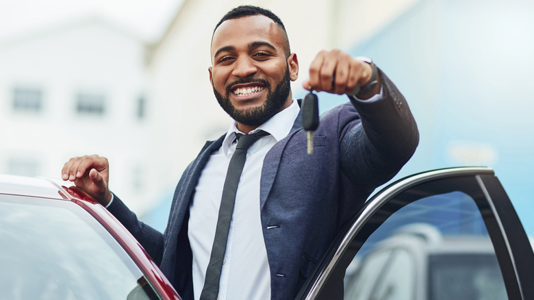 man with key by car