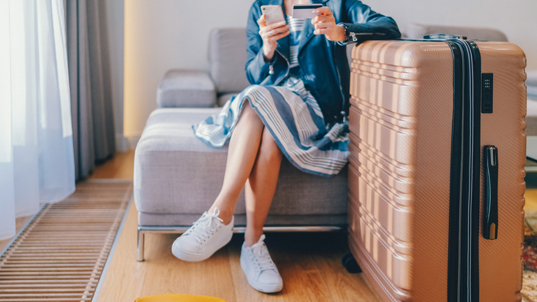 person relaxing next to suitcase