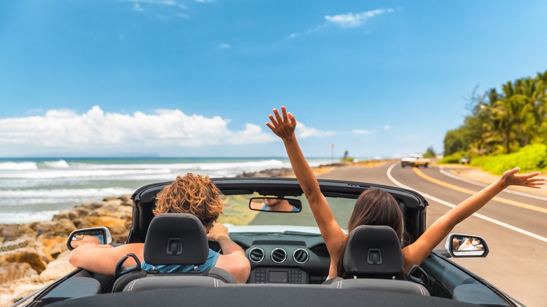 Couple driving down coastal road