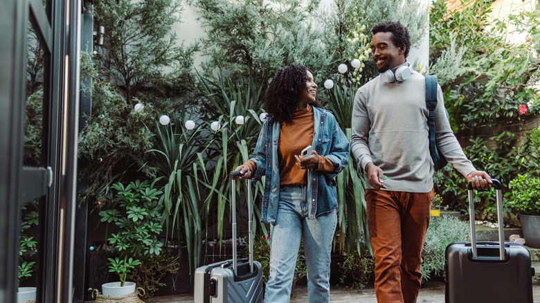 Couple with luggage entering vacation rental