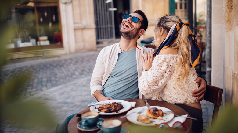 Couple laughing at restaurant in Italy