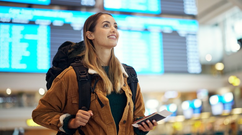 Happy backpacker walking through airport