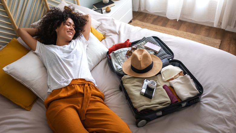 Woman next to packed luggage