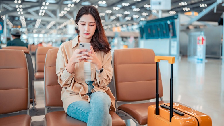 Woman at airport checking phone