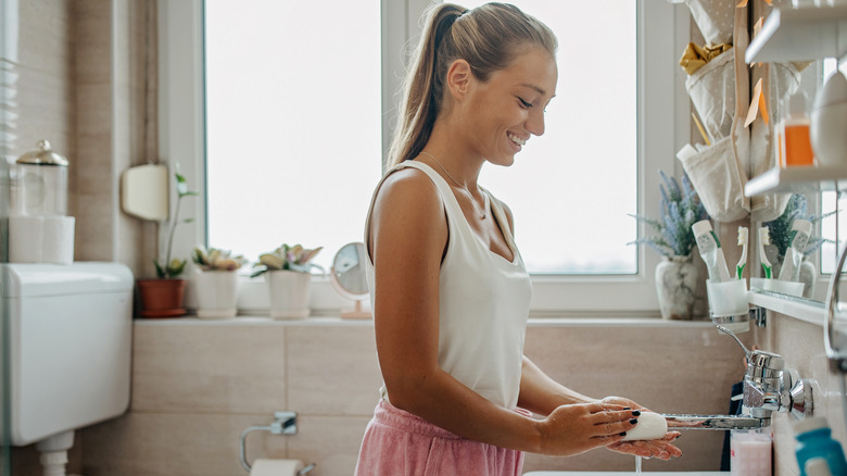 woman doing laundry in bathroom