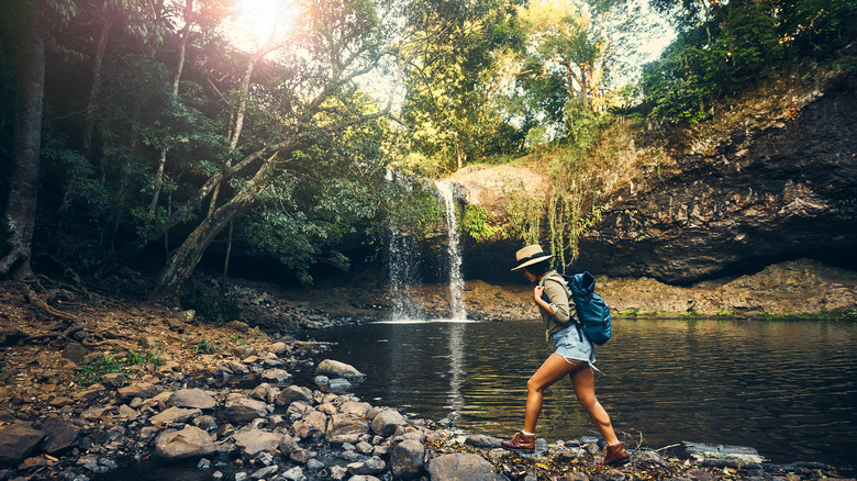 Woman hiking by a small waterfall