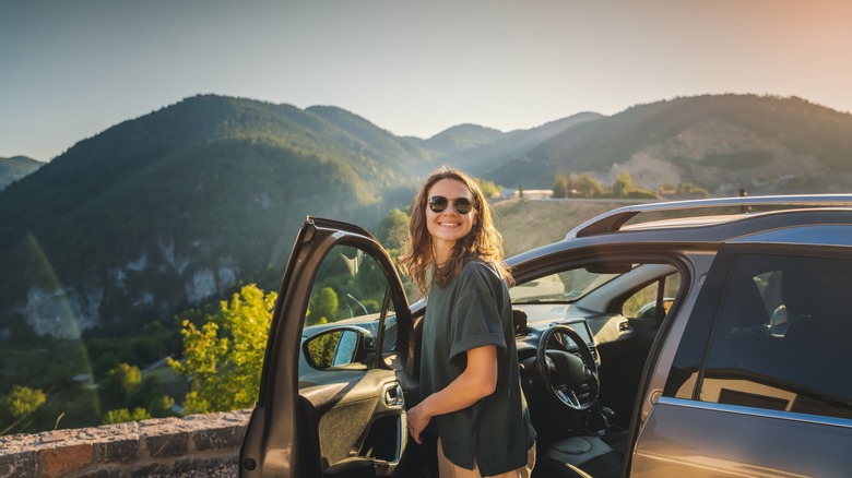 Woman standing next to car