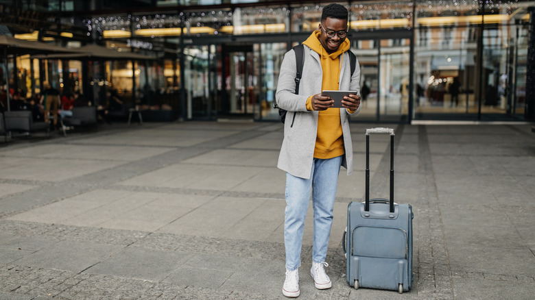 man with suitcase and backpack