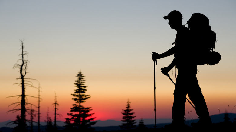 Backpacker silhouetted against sunrise