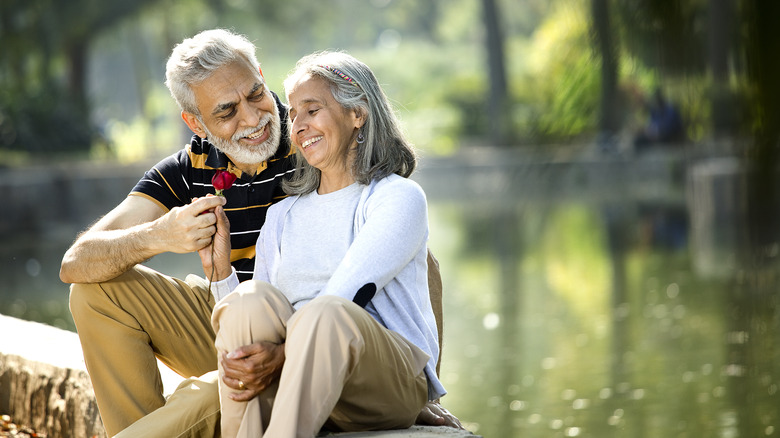 Elderly couple sitting near water