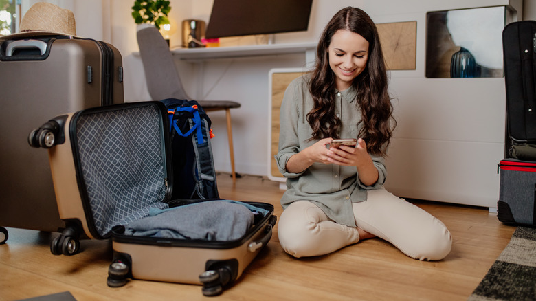 Traveler packing suitcase on the floor