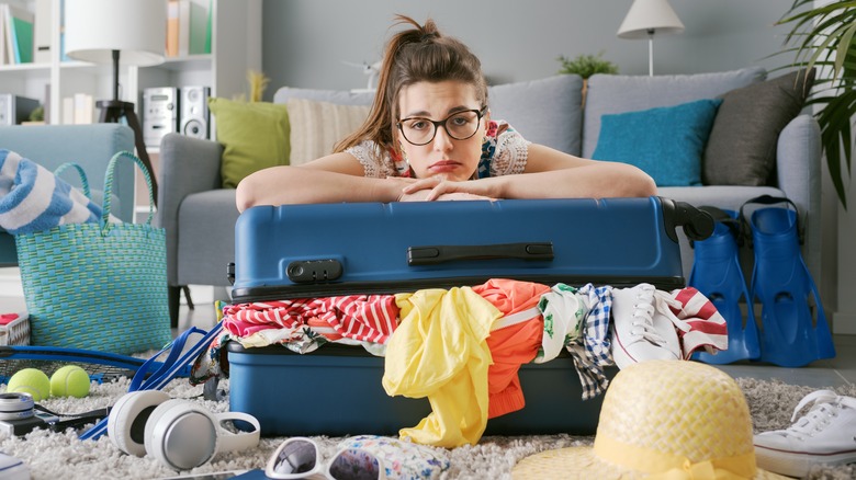 sad woman with messy luggage